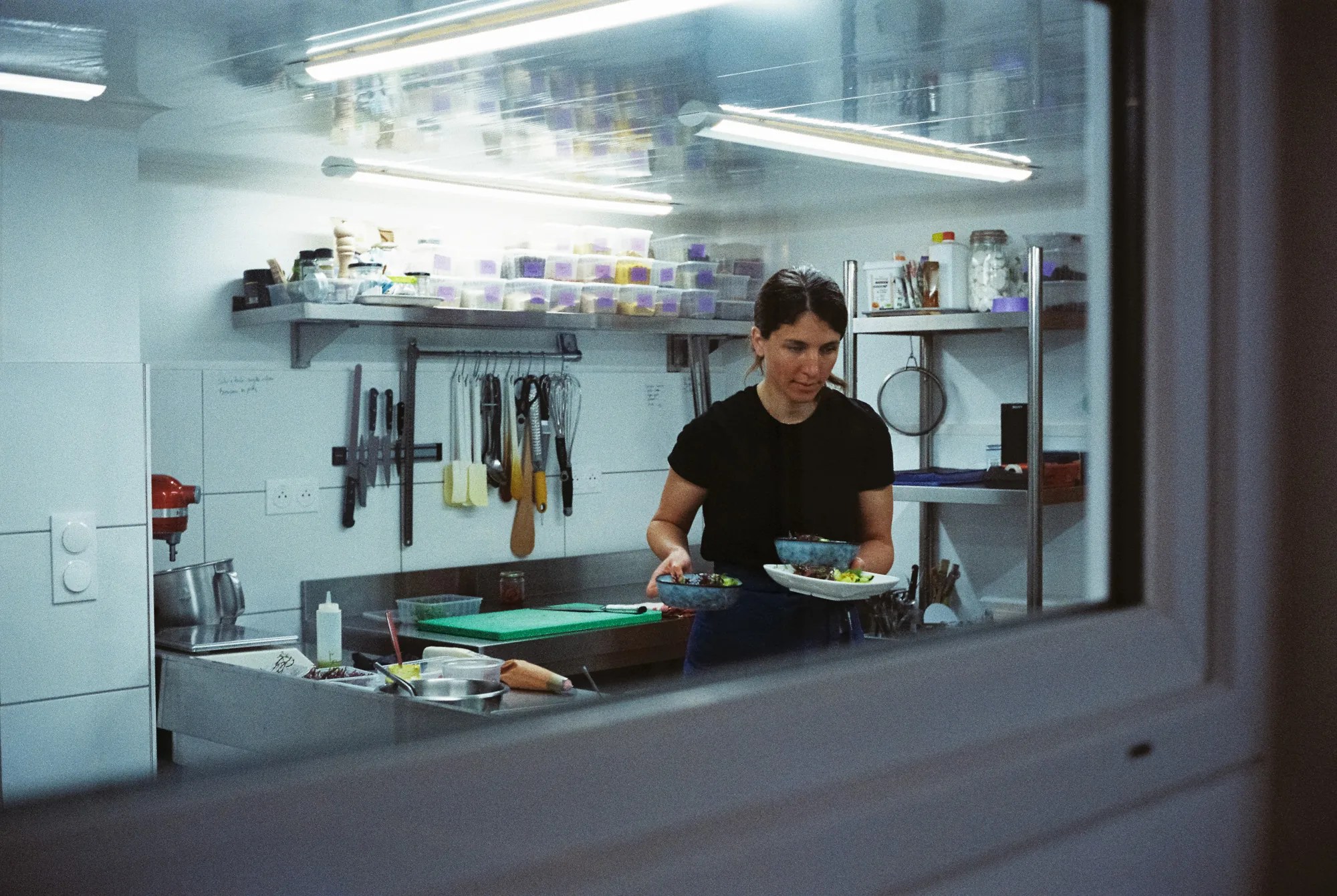 Cheffe traiteur vegan dans son laboratoire professionnel préparant des plats végétaux dans le Morbihan